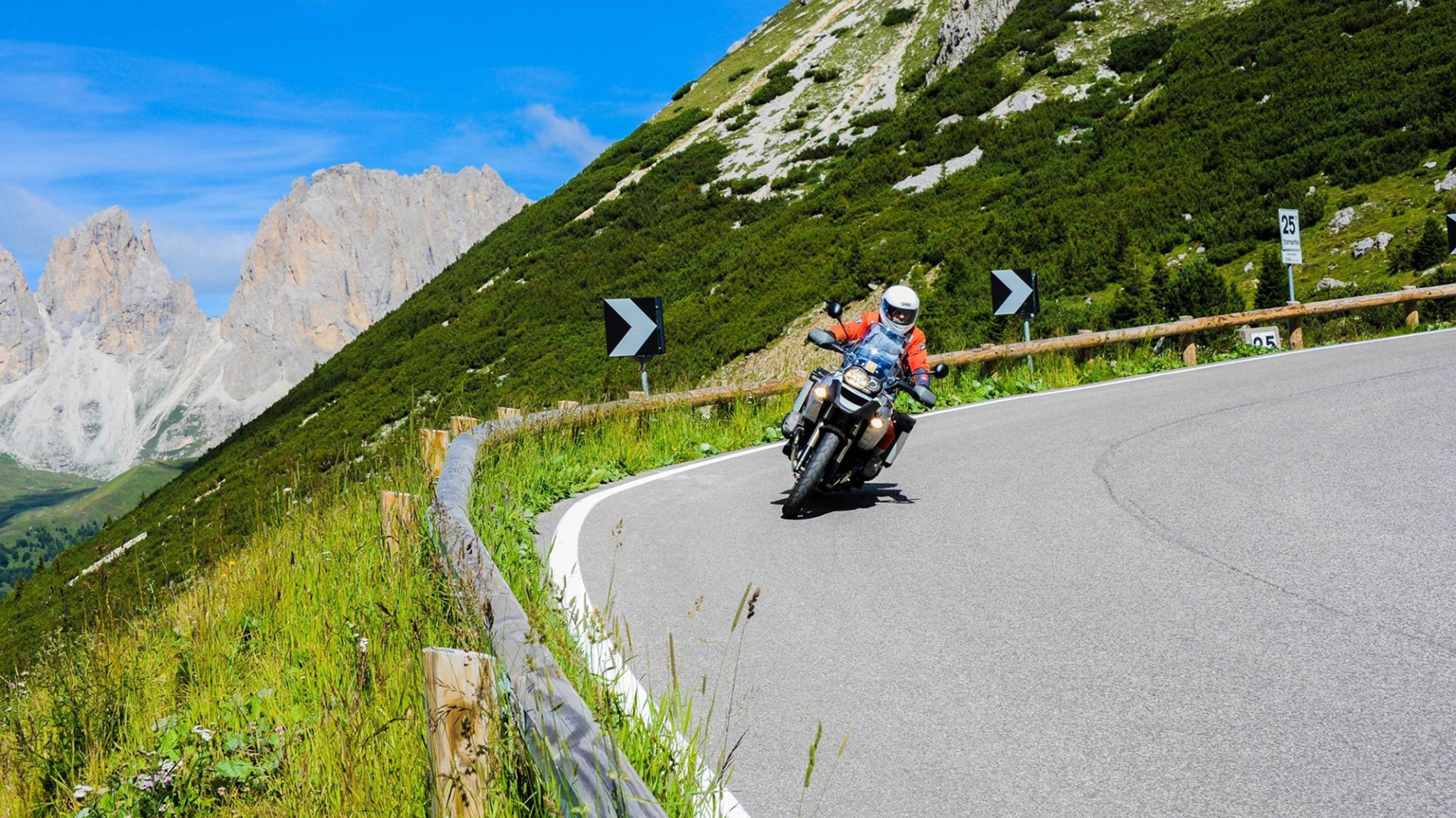 Motorradfahrer fährt um die Kurve Mitten in den Dolomiten