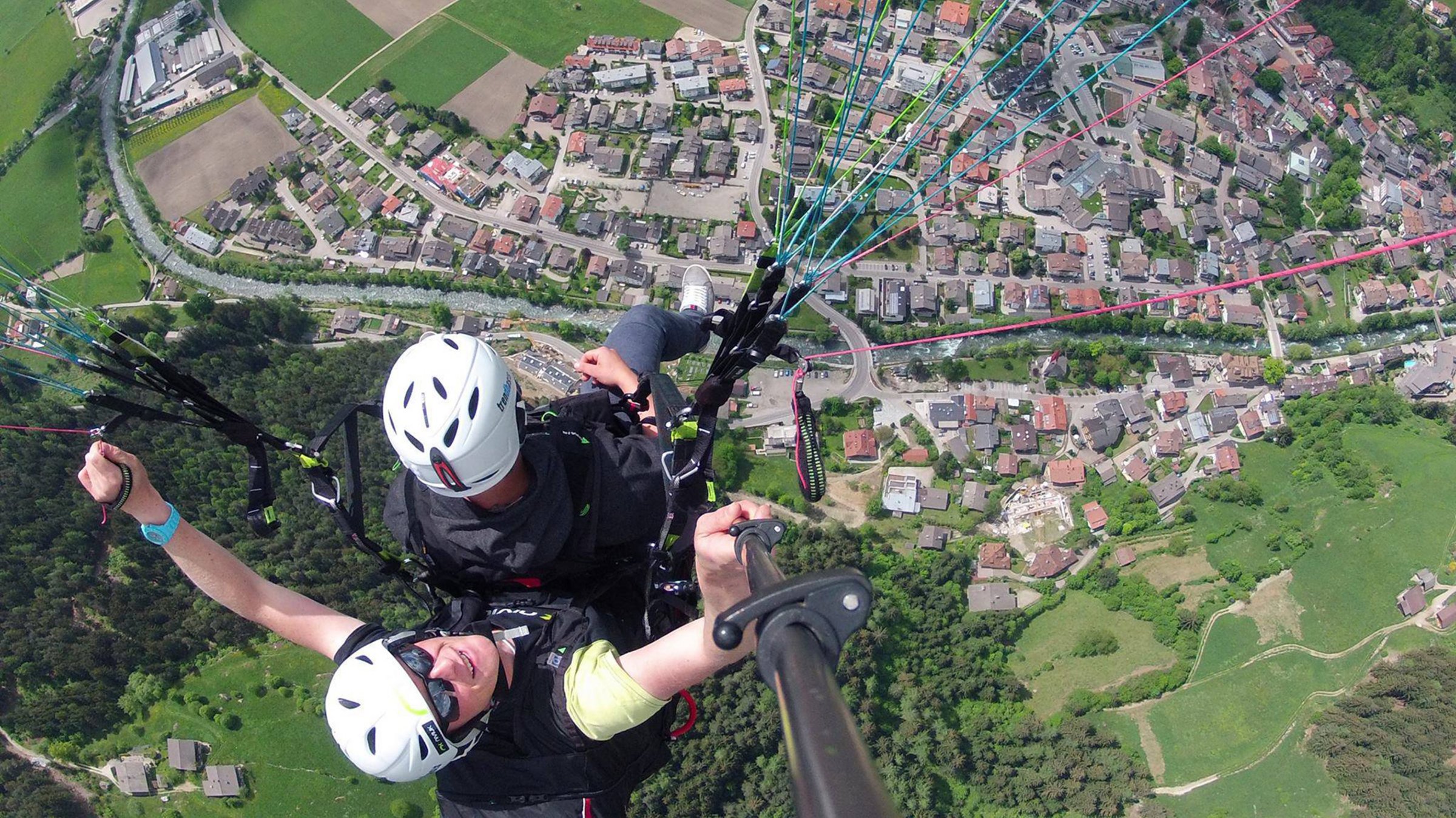 Zwei Gleitschirmflieger fliegen über Kastelruth